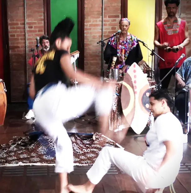 Jovens do projeto Cantinho Feliz jogando capoeira.