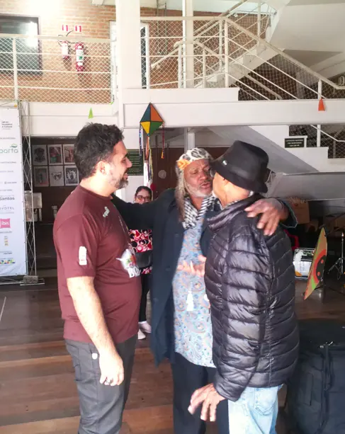 Dirigente do Instituto Arte No dique conversando com artistas do Clube de Bambas à direita.