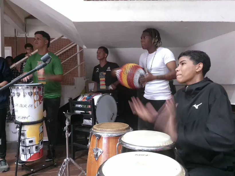 Jovens alunos de percussão do Instituto Arte no Dique se apresentando ao vivo.