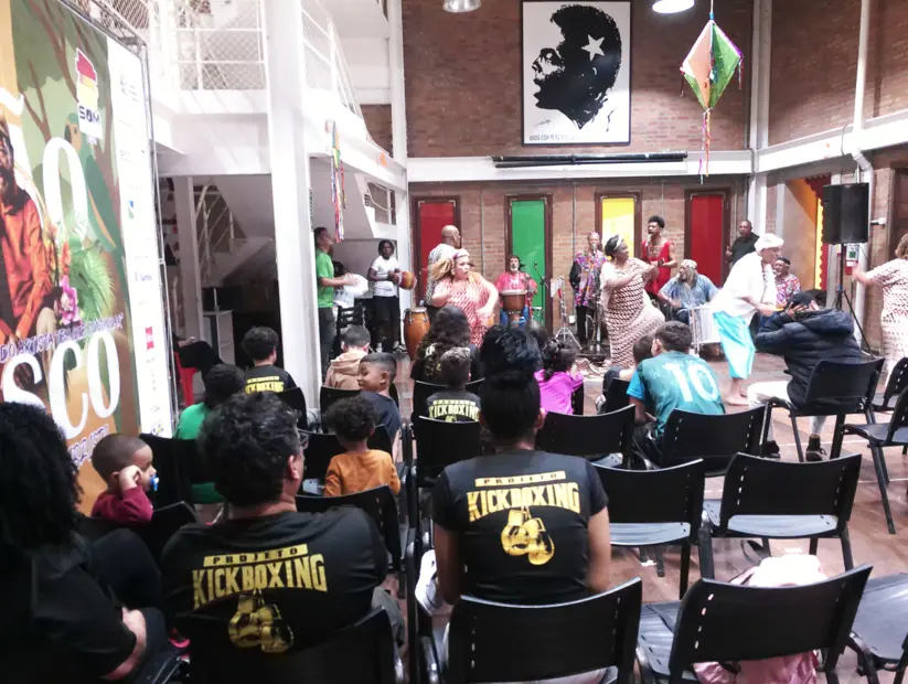 Plateia de jovens assistindo ao espetáculo musical.