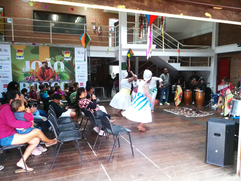 Plateia de crianças, jovens e adultos assistindo à participação do Balé Afro no espetáculo musical.