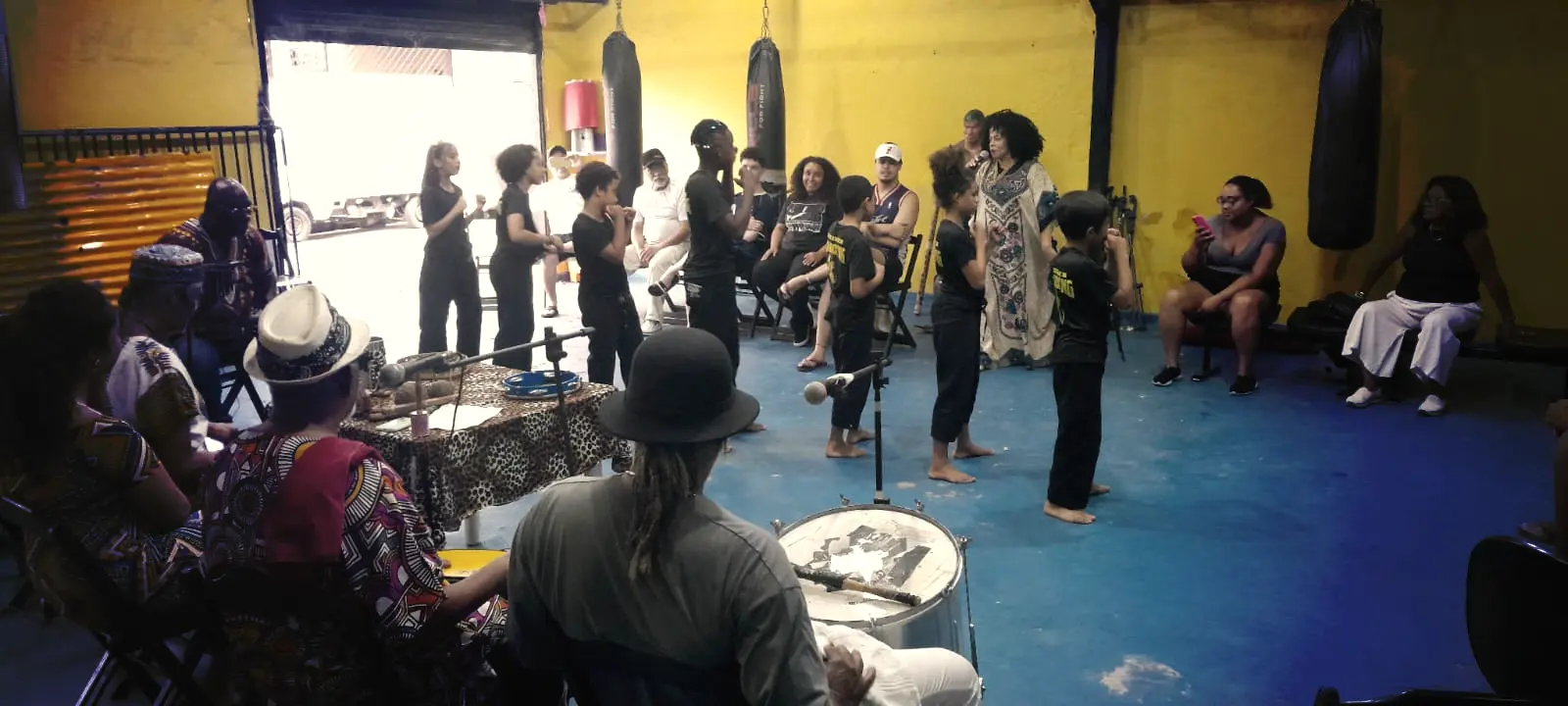 Crianças se apresentando com sua educadora.